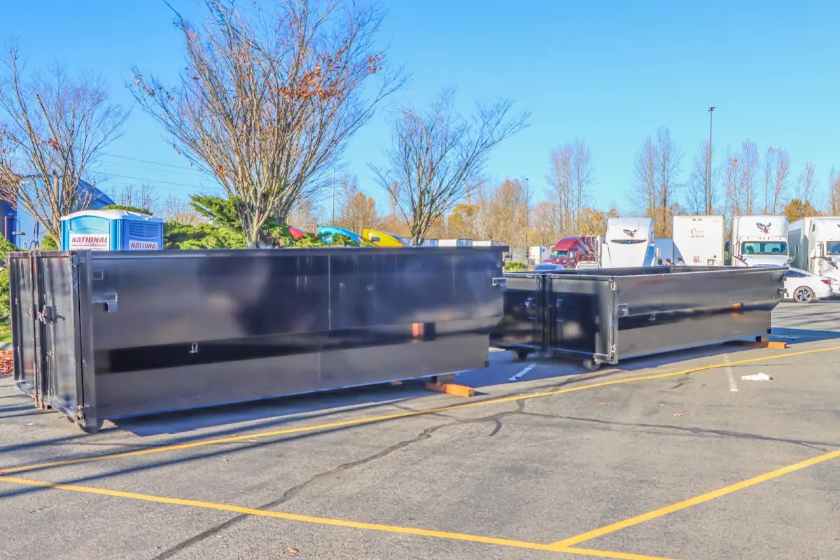 Professional dumpster rental service with roll-off container on residential driveway in Dorr